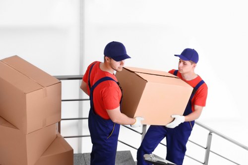 Professional team handling piano removals in Ilford with protective equipment